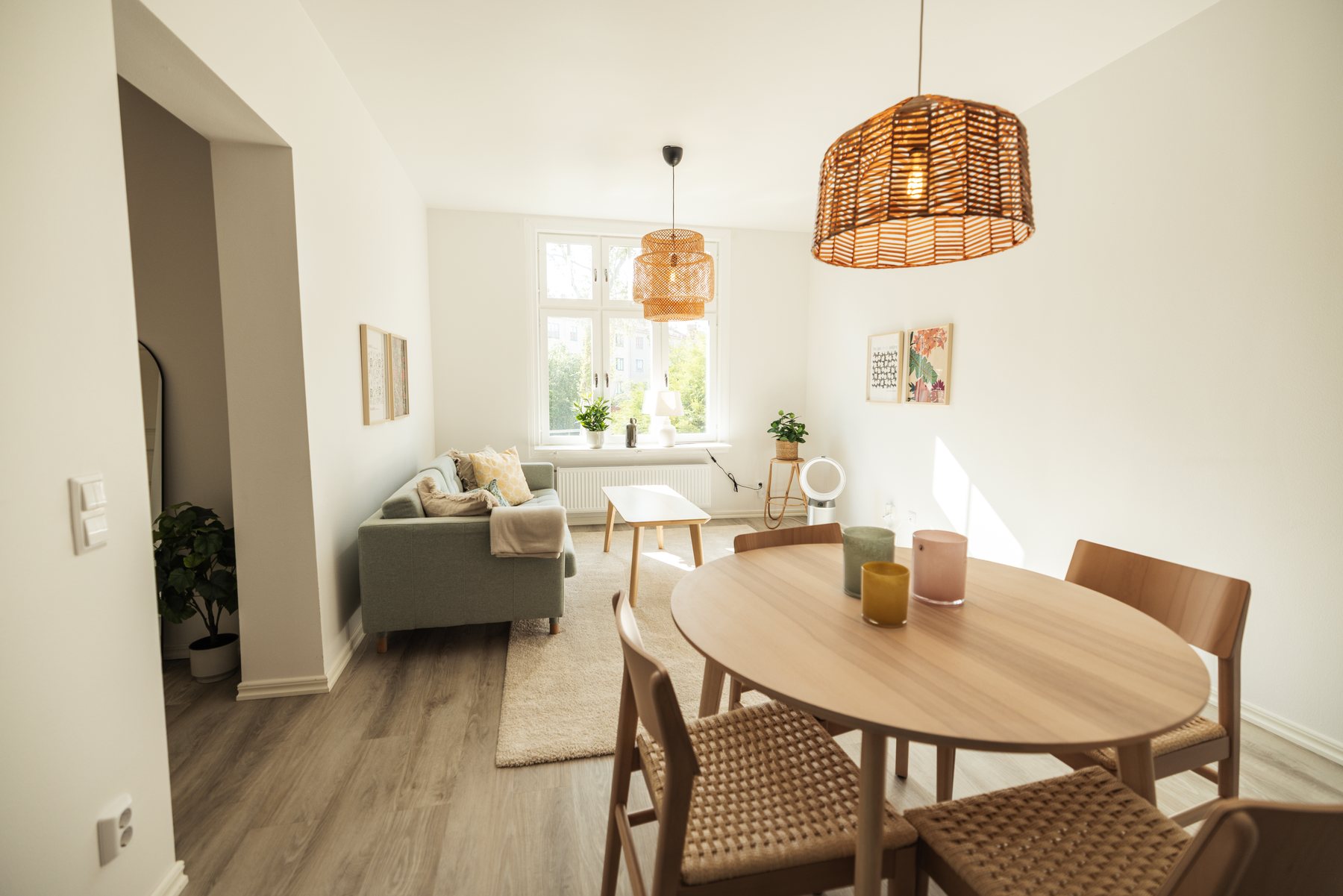 Rund matplats för fyra med vardagsrummet och de stora fönstren i bakgrunden